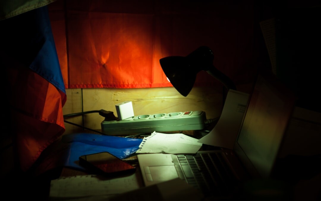 Desk covered with government documents, folders and a magnifying glass used for investigative research